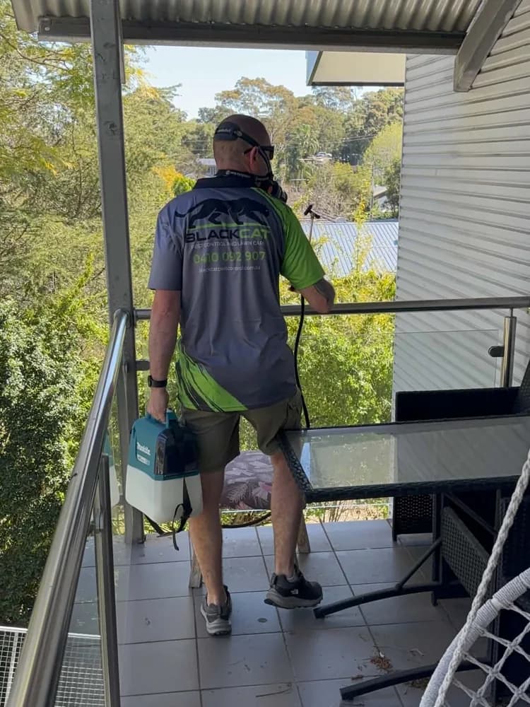 Wayne in his Black Cat shirt treating a home in Western Sydney